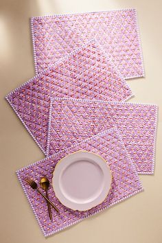 three placemats and one plate on a table with utensils next to them