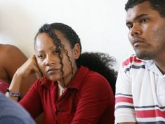 three people sitting next to each other with their faces painted like the same man and woman