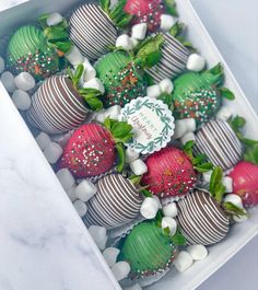 chocolate covered strawberries in a box with white and green decorations