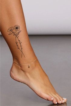 a woman's foot with a flower tattoo on it