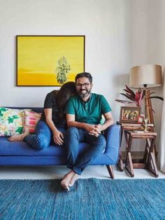 a man and woman sitting on a blue couch