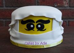 there is a cake made to look like a lego head with eyes and eyebrows on it