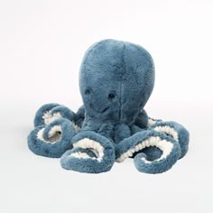 an octopus stuffed animal with white teeth on it's face and mouth, sitting in front of a white background