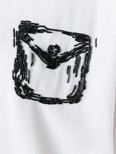 a white t - shirt with black beading on it