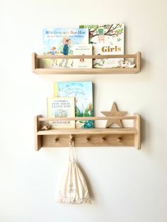 two wooden shelves with books on them against a white wall in a child's room