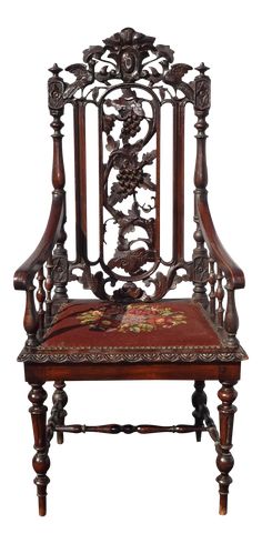 an ornate wooden chair with red upholstered seat and arm rests against a white background