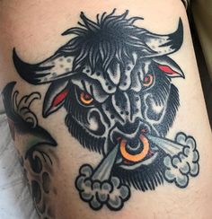 a bull with horns and clouds on it's back leg is depicted in this tattoo design