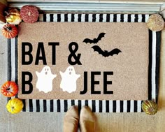 a door mat that says bat & booe with two ghost feet on it and pumpkins