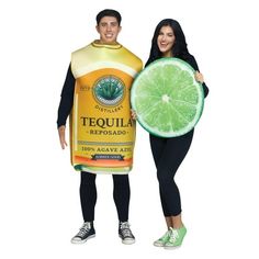 a man and woman holding a large bottle of tequila with a lime slice on it