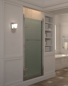 a bathroom with a glass shower door and white shelves filled with towels on the wall