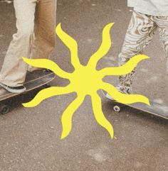 two skateboarders are riding their boards with the sun painted on them's side