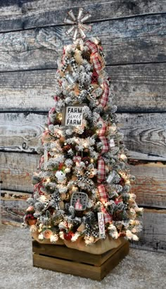 a small christmas tree decorated with silver and red ornaments on top of a wooden stand