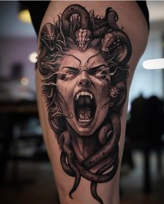 a woman's thigh with an evil face and snake around her head, in black and white