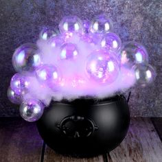 a black pot filled with bubbles on top of a wooden table