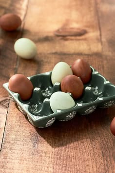 an egg tray filled with eggs on top of a wooden table