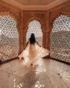 a woman in a white dress is walking through an archway