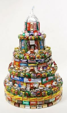 a multi - tiered christmas tree made out of candy bar wrappers and candies