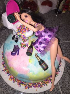 a barbie doll sitting on top of a cake with confetti around her ankles