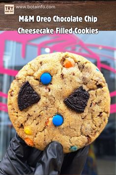 a person holding up a giant cookie with m & m oreo chocolate chips on it