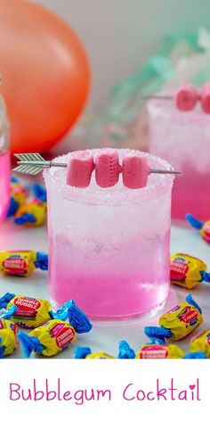 a pink cocktail with candy on the rim