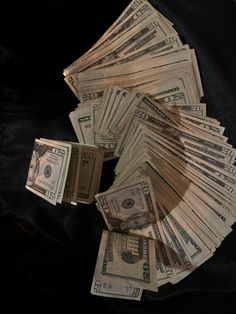 a pile of money sitting on top of a black cloth