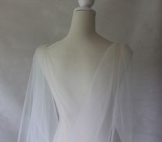 the back of a white wedding dress on a mannequin headdress,