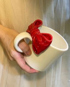 a person holding a cup with a red bow on it