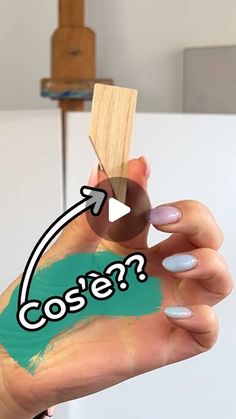 a woman's hand holding a piece of wood with the word cooe? painted on it