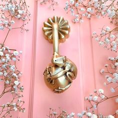 a gold door handle on a pink door