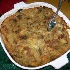 a casserole dish with meat and vegetables in it next to a glass of milk