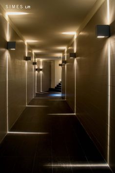 an empty hallway with lights on the walls