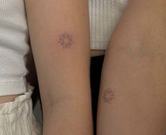 two women with matching tattoos on their arms, both have sun and moon tattoo designs