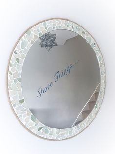 there is a mirror that says shore things in blue writing on the bottom half of it