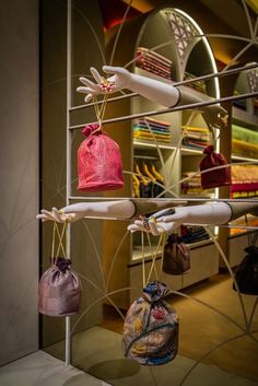 several purses hanging from hooks in a store