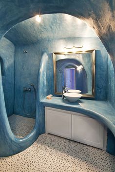 a blue bathroom with a sink and mirror