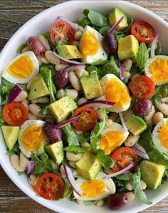 a white bowl filled with salad and eggs