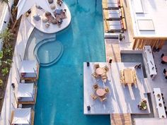 an aerial view of a pool with chairs and tables