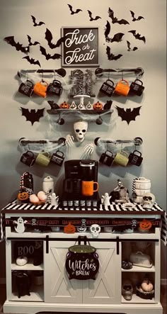 a halloween themed kitchen with black and white decor on the wall, bats hanging from the ceiling