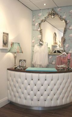 the inside of a clothing store with flamingos on the wall and mirror above it