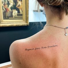 the back of a woman's neck with a tattoo that reads, beyond your own passion