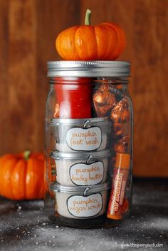 a jar filled with candy and pumpkins sitting on top of a table