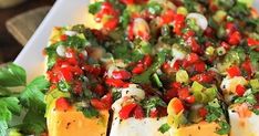 a white plate topped with tofu covered in salsa and garnished with cilantro