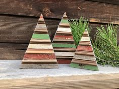 three wooden christmas trees sitting on top of a table