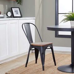 a dining room table with two chairs and a potted plant