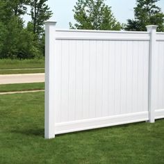 a white fence in the middle of some grass