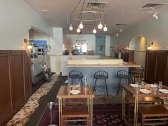 the inside of a restaurant with tables, chairs and bar stools on carpeted flooring