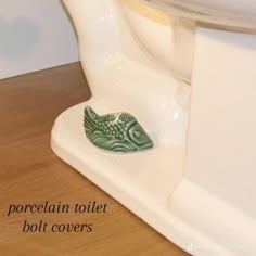 there is a small green fish on the toilet seat cover that says porcelain toilet cover