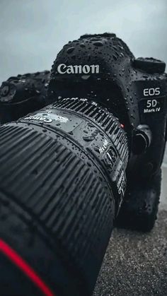 a canon camera sitting on top of a wet ground