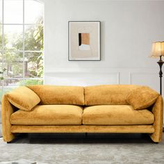 a living room scene with focus on the couch and floor lamp in the foreground