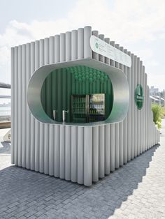 an unusual building with green balls on the outside and white columns around it's entrance